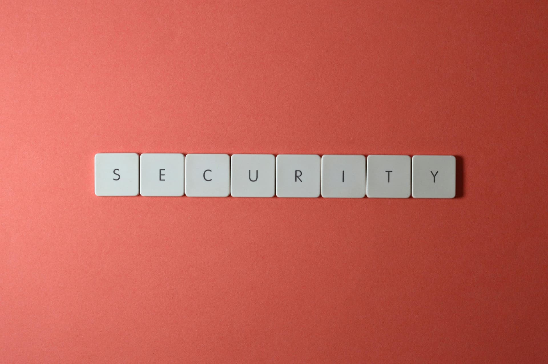 White keyboard keys spelling "SECURITY" on a coral background.
